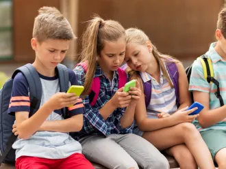 A group of children look at their phones.