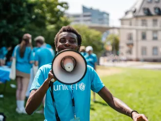 Youth wearing UNICEF t-shirt speaking into megaphone