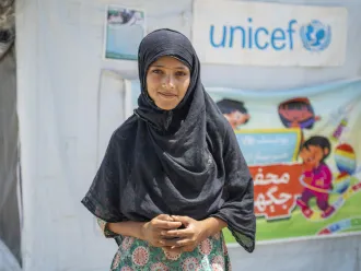 Young girl stands outside a UNICEF Child Friendly Space in Sindh, Pakistan.