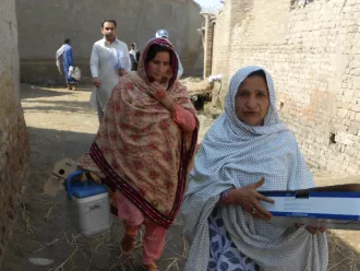 UNICEF-supported "lady health workers" Jameela, right, and Shamul visit the village of Peer Jo Goth in Pakistan's Kambar District to vaccinate women of childbearing age against tetanus.