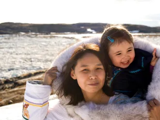 An Inuit mother carries her child in her amouti