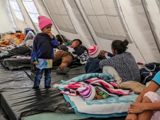 child standing in a UNICEF temporal rest tent in Rumichaca, Ecuador