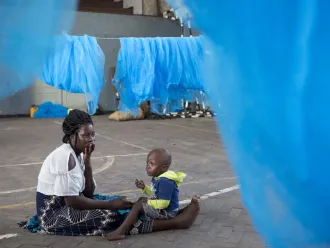 woman and chjld surrounded by mosquito nets