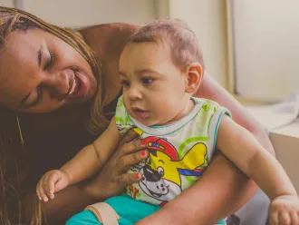 A mother plays with her young baby