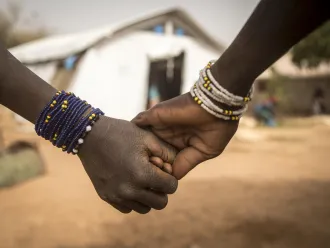 Two girls hold hands outside a UNICEF supported centre.