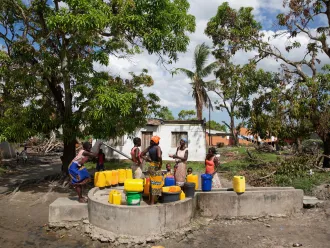 A woman fill jerricans at a community water point. 
