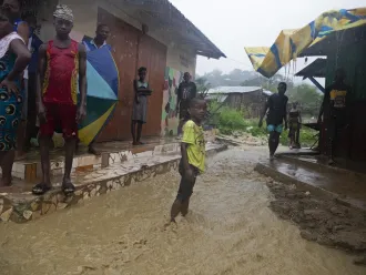 Boy stands in flooded streets in Pemba, Mozambique