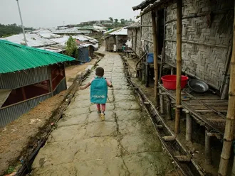 kid walk in rohingya camp during monsoon
