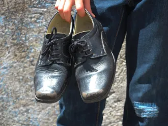 Angel Ganriel holds his new uniform shoes.