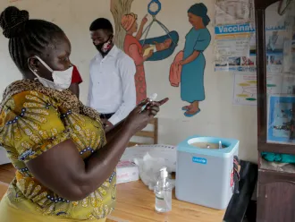 On 8 October 2020 at Gurei Health Care Centre in Juba, South Sudan, Elisabeth Abraham Loro, nurse and vaccinator, collects vaccines from a cold box.