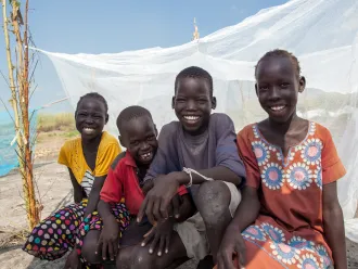 Friends sit by a UNICEF-supplied mosquito net in Bienythiang in Akoka county, Upper Nile state, South Sudan on 23rd October 2020.