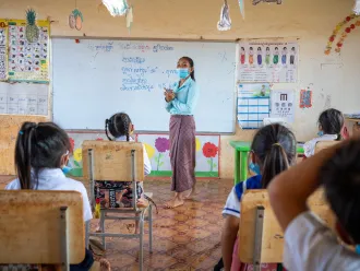 05 November 2020, Trom Village, Laminh Commune, Borkeo District, Rattanakiri, Cambodia. Portrait of MORN Sambo, 27, teacher at the village primary school of Trom, teaching a disabled student. 