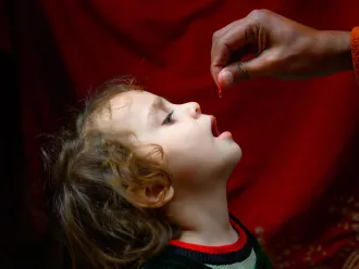 A four year old girl receives Vitamin A form Ajmal, a polio vaccinator in Lahore during Pakistan's first national campaign of the year, aiming to vaccinate over 40 million children under five year of age against polio and provide Vitamin A supplementation.