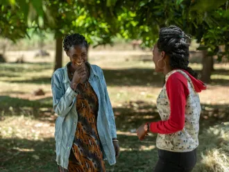 A woman and her daughter talk outside their home.