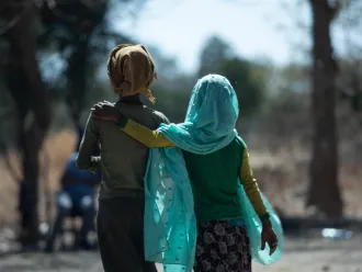 Two girls walk down a road in Ethiopia.