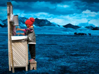 A child washes their hands at a portable station in Mongolia.