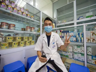 A health worker gives the 'V for Vaccinated' sign at a hospital in Vietnam.
