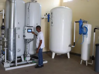 A technician checks an oxygen plant in Uganda.