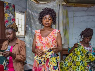 Students pose together at the sewing studio.