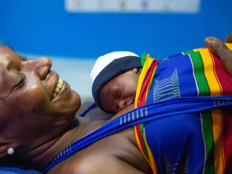 A mother practices kangaroo care with her newborn baby at a hospital.