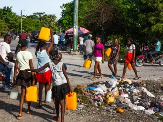 Young adults look for clean water in the city of Les Cayes, Haiti on 15 August 2021, following the 7.2 magnitude earthquake that struck on 14 August 2021.