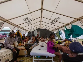 On 17 August 2021, patients of Ofatma Hospital in Les Cayes, Haiti and their families wait for medical attention in a UNICEF-supplied tent in the hospital's courtyard. UNICEF installed the tents to shelter patients who feared the hospital building could collapse.