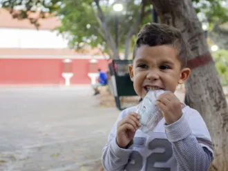 A child eats from a packet of ready-to-use therapeutic food in Venezuela.