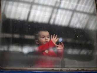 A child looks out from a carriage window