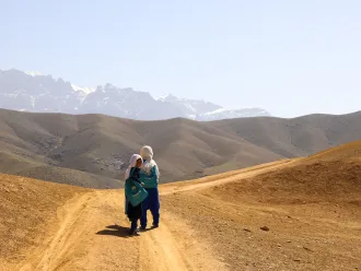 The students of Warkak's accelerated learning center in Daikundi Province walk home together over the dusty hills.