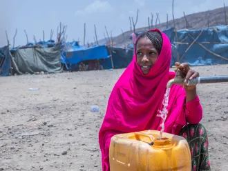 On 10 May 2022 in the internally displaced person (IDP) site of Guyah, Afar Region, Ethiopia, 13-year-old Keria fetches water from a UNICEF supported water point.