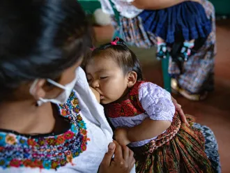 A woman breastfeeds a child.