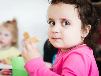 A child enjoys their lunch in school cafeteria 