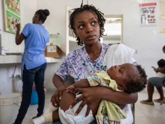 A woman is holding a child in her arms.