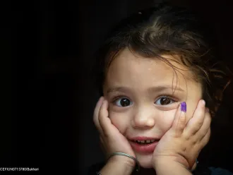 4-year-old Gul-e-Rukh poses for the UNICEF camera, showing her marked finger after receiving the polio vaccine, in Karachi, Pakistan.