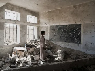 un enfant dans une classe détruite au Yémen
