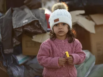 A little girl stands amongst the boxes of supplies sent to the survivors of the 7.7 magnitude earthquake in Kahramanmaraş, Türkiye.