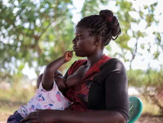 Amal Esther, a Care Group Volunteer from Cluster K, Panyadoli Refugee Settlement in Kiryandongo District breastfeeds her baby Anena on 3 March, 2023.