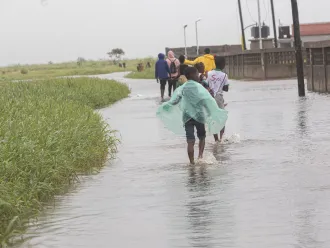 March 13, 2023. A group of children walks through a flooded street after Cyclone Freddy passes through Quelimane on March 11.