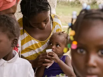 Child eating peanut plan at a health center for nutrition. Mare Briole, departement South-East, Haiti, September 2019.