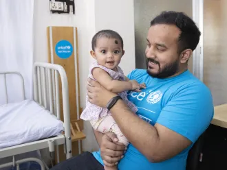 Le conseiller de l’UNICEF, Anindya Shubhra Banerjee, joue avec une petite fille à la garderie de la clinique Alo. Le 13 février 2023, Shyampur.
