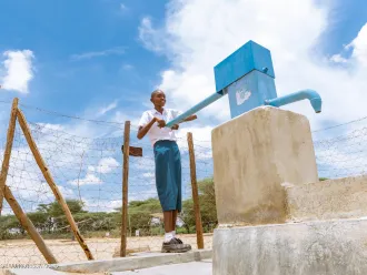 In Turkana, Kenya a young girl uses a handpump for water
