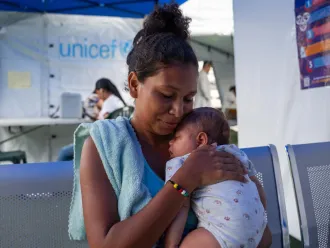 A woman holds a baby at a temporary health clinic. 