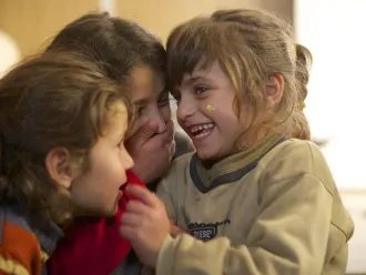 Safa (right) laughs with her twin sister and older sister.