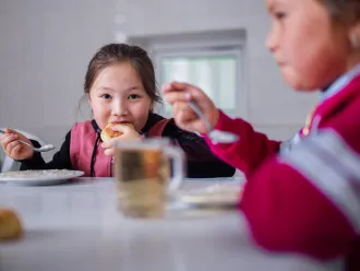 A girl eats a healthy school lunch.