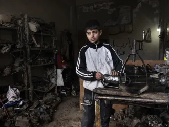 13 year old Ibrahim works in a mechanics shop to help support his family in Syria.