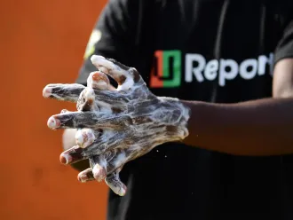 A U-Reporter demonstrates proper handwashing techniques in Cote D'Ivoire.