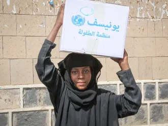 After being displaced by ongoing insecurity a young girl helps her family carry home a basic hygiene kit. They received urgent support through the Rapid Response Mechanism in Shuab