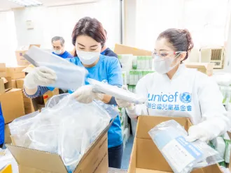 UNICEF workers unpacking with face masks on