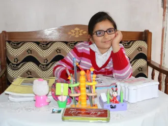 Masa, age 9, studies at her home in Syria.