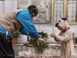 A UNICEF Italy staff member demonstrates handwashing to a young migrant girl.